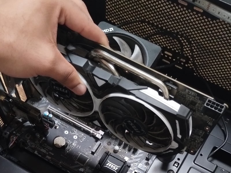 image showing hands pulling out a GPU